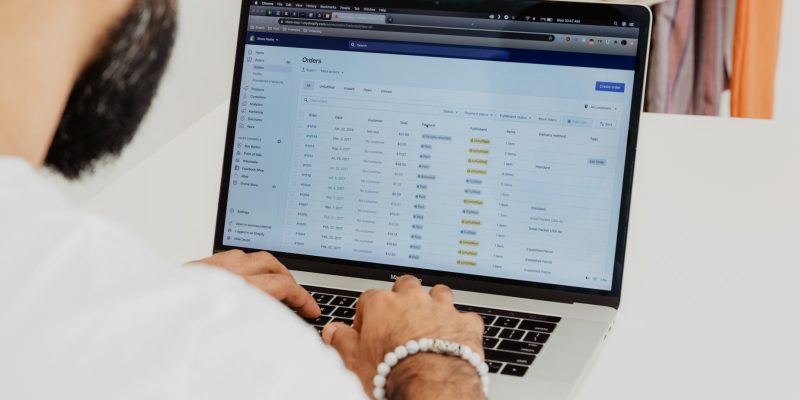 Shopify store owner reviewing orders in the Shopify admin on a laptop — choosing a partner from the Shopify Partner Directory